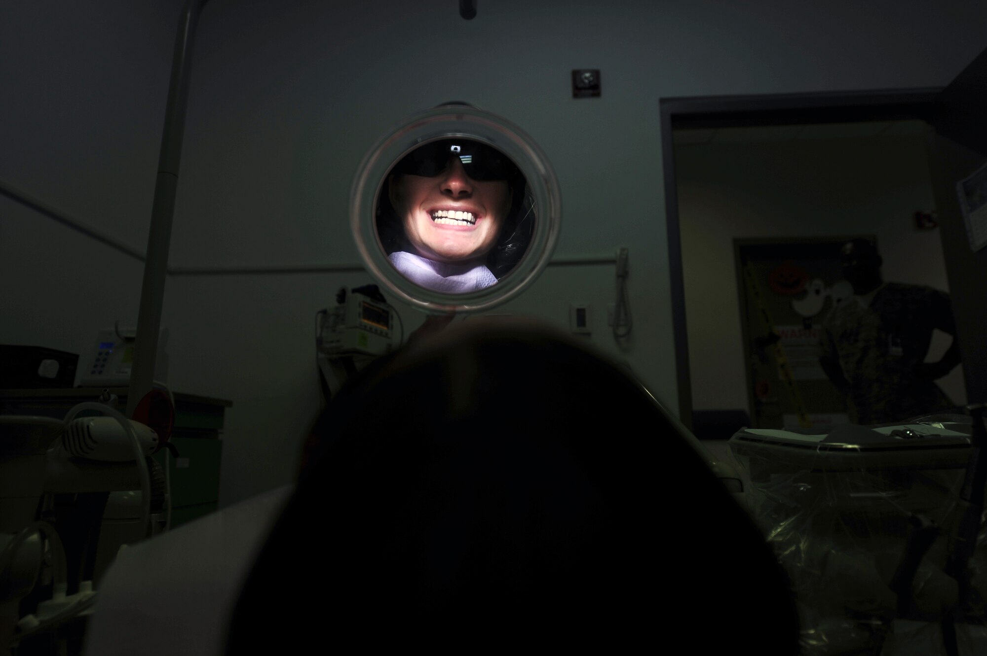 A patient smiles in a mirror after having a cavity filled Oct. 20, 2011, at an undisclosed location in Southwest Asia. The 379th Expeditionary Medical Group dental clinic averages from five to seven emergency patients a day. Dental sick call hours are Monday to Saturday from 7 - 11 a.m. and noon to 4 p.m. on a walk-in basis. (U.S. Air Force photo/Senior Airman Paul Labbe)
