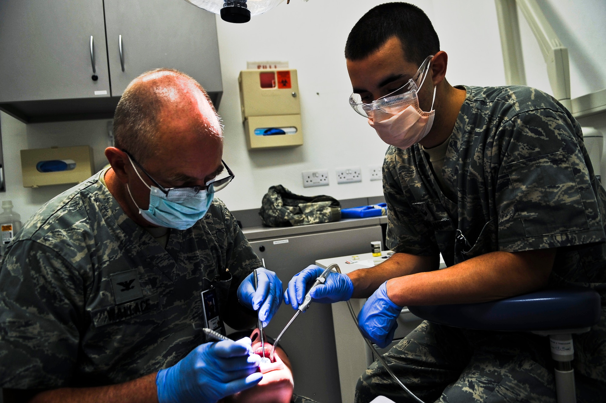 Col. (Dr.) Mark Wallace (left), 379th Expeditionary Aero Medical Dental Flight Commander, and Senior Airman Kyle Wireman, 379th EAMDF dental assistant, check for cavities Oct. 20, 2011, at an undisclosed location in Southwest Asia. Dental sick call hours are Monday - Saturday from 7 - 11 a.m. and noon to 4 p.m. on a walk-in basis. Wallace, a native of Salt Lake City, Utah, is deployed from Maxwell Air Force Base, Ala. Wireman, a native of Albion, Ind., is deployed from Lackland Air Force Base, Texas. (U.S. Air Force photo/Senior Airman Paul Labbe)