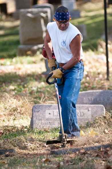 Senior Master Sgt. Dwane King, ground safety monitor for the 139th Airlift Wing, Missouri Air National Guard, cuts weeds at Mount Mora Cemetery in St. Joseph, Mo., Oct. 25, 2011. Members of the 139th AW volunteered with lawn maintenance of the graveyard where the Wing’s first commander, Col. John B. Logan, is buried. (U.S. Air Force photo by Staff Sgt. Michael Crane/Missouri Air National Guard)