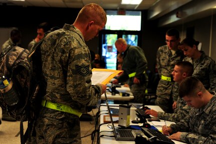 Senior Airman Kevin Roberts checks-in Tech. Sgt. Kevin Dunn during an Operational Readiness Exercise at Joint Base Charleston Oct. 25. The ORE is in preparation for the command's upcoming Operational Readiness Inspection which evaluates Airmen's mission readiness in preparation for real world deployments.   Roberts is assigned to the 437th Aerial Port Squadron and Dunn is assigned to the 437th Aircraft Maintenance Squadron.  (U.S. Air Force photo/ Staff Sgt. Nicole Mickle) 