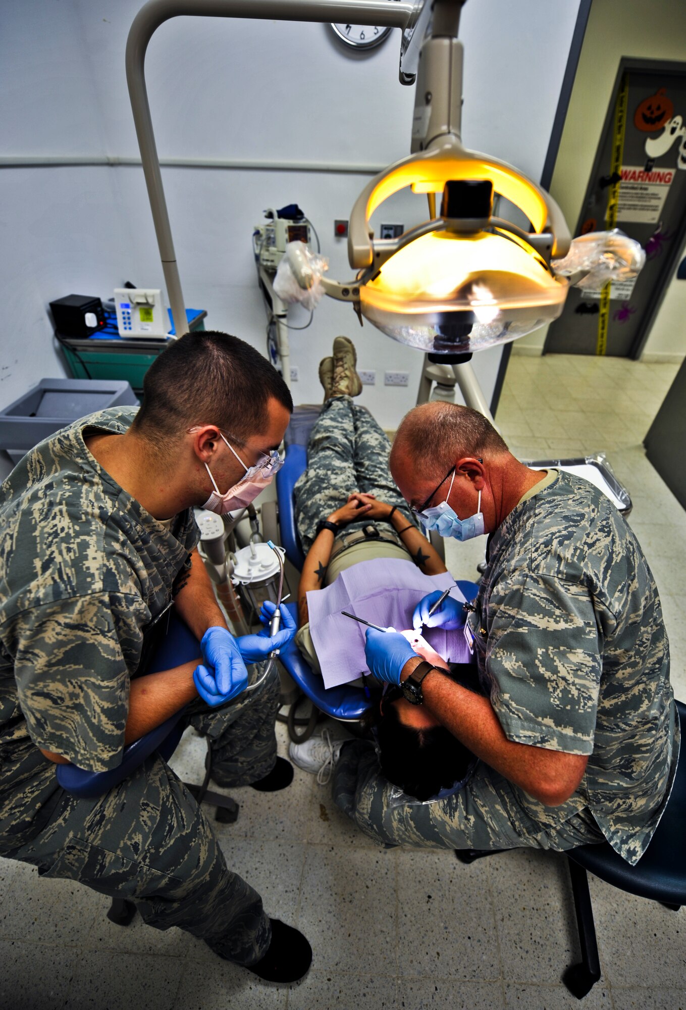 Col. (Dr.) Mark Wallace (right), 379th Expeditionary Aero Medical Dental Flight Commander,  and Senior Airman Kyle Wireman, 379th EAMDF dental assistant, prepare to fill a cavity in a patient’s mouth, Oct. 20, 2011, at an undisclosed location in Southwest Asia. Dental sick call hours are Monday - Saturday from 7 - 11 a.m. and noon to 4 p.m. on a walk-in basis. Wallace, a native of Salt Lake City, Utah, is deployed from Maxwell Air Force Base, Ala. Wireman, a native of Albion, Ind., is deployed from Lackland Air Force Base, Texas. (U.S. Air Force photo/Senior Airman Paul Labbe)