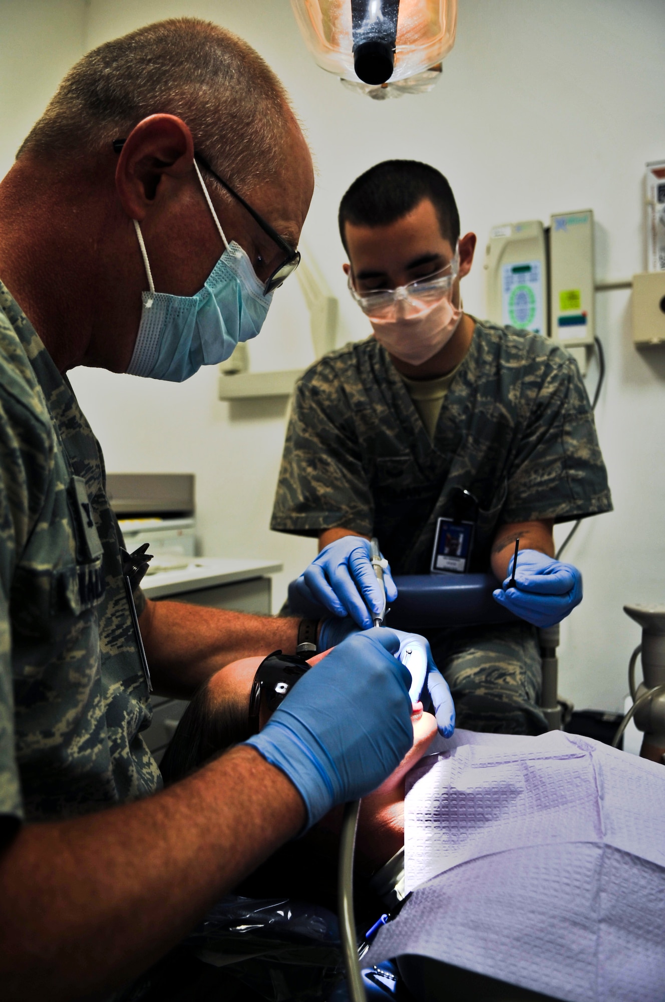 Col. (Dr.) Mark Wallace (left), 379th Expeditionary Aero Medical Dental Flight commander, and Senior Airman Kyle Wireman, 379th EAMDF dental assistant, rinse a patient’s mouth before filling a cavity, Oct. 20, 2011, at an undisclosed location in Southwest Asia. Dental sick call hours are Monday - Saturday from 7 - 11 a.m. and noon to 4 p.m. on a walk-in basis. Wallace, a native of Salt Lake City, Utah, is deployed from Maxwell Air Force Base, Ala. Wireman, a native of Albion, Ind., is deployed from Lackland Air Force Base, Texas. (U.S. Air Force photo/Senior Airman Paul Labbe)