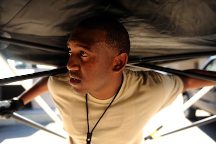 Staff Sgt. Stephen Kohn, holds up the side of a tent during an Operational Readiness Exercise in Gulfport, Miss., Oct. 24. The ORE is in preparation for the command's upcoming Operational Readiness Inspection which evaluates Airmen's mission readiness in preparation for real world deployments. Kohn is from the 628th Security Forces Squadron.  (U.S. Air Force photo by Staff Sergeant Chad Trujillo/not reviewed)