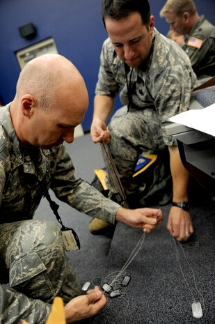 Col. Justin Davey, 628th Mission support Group commander and Lt. Col. Andrew Leone, 315th Mission Support Group deputy commander, sort through dog tags during the Operational Readiness Exercise  in Gulfport, Miss., Oct. 24. The ORE is in preparation for the command's upcoming Operational Readiness Inspection which evaluates Airmen's mission readiness in preparation for real world deployments.(U.S. Air Force photo/Staff Sgt. Chad Trujillo)