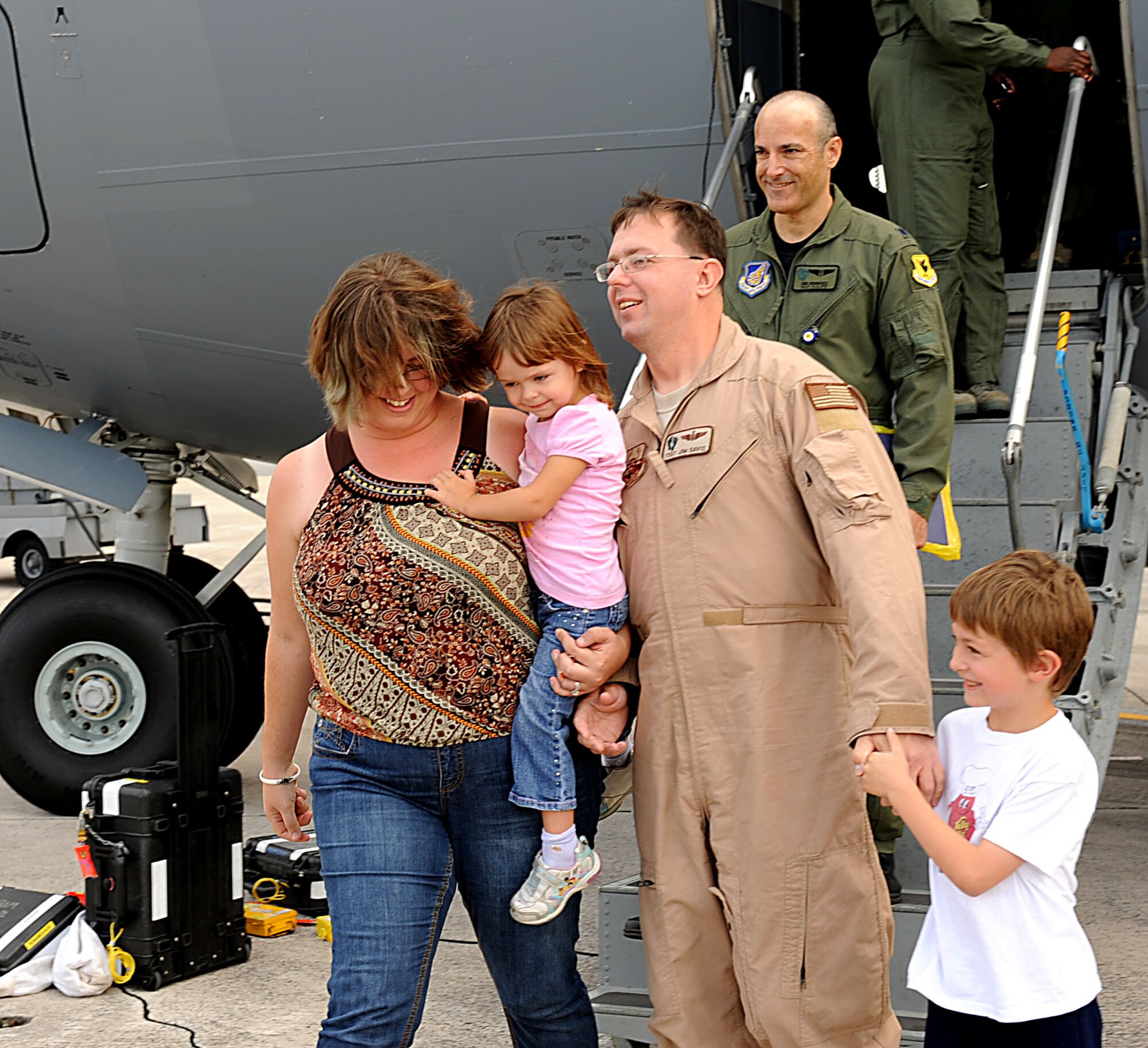 U.S. Air Force Tech. Sgt. James Davis, 33rd Rescue Squadron flight engineer, walks out of a U.S. Air Force C-17 Globemaster III cargo plane with his family after returning home to Kadena Air Base, Japan, Oct. 26. Davis has spent the last few months going through rehabilitation for a gunshot wound he acquired while serving in Afghanistan this spring. (U.S. Air Force photo/Airman 1st Class Brooke P. Beers/Released)
