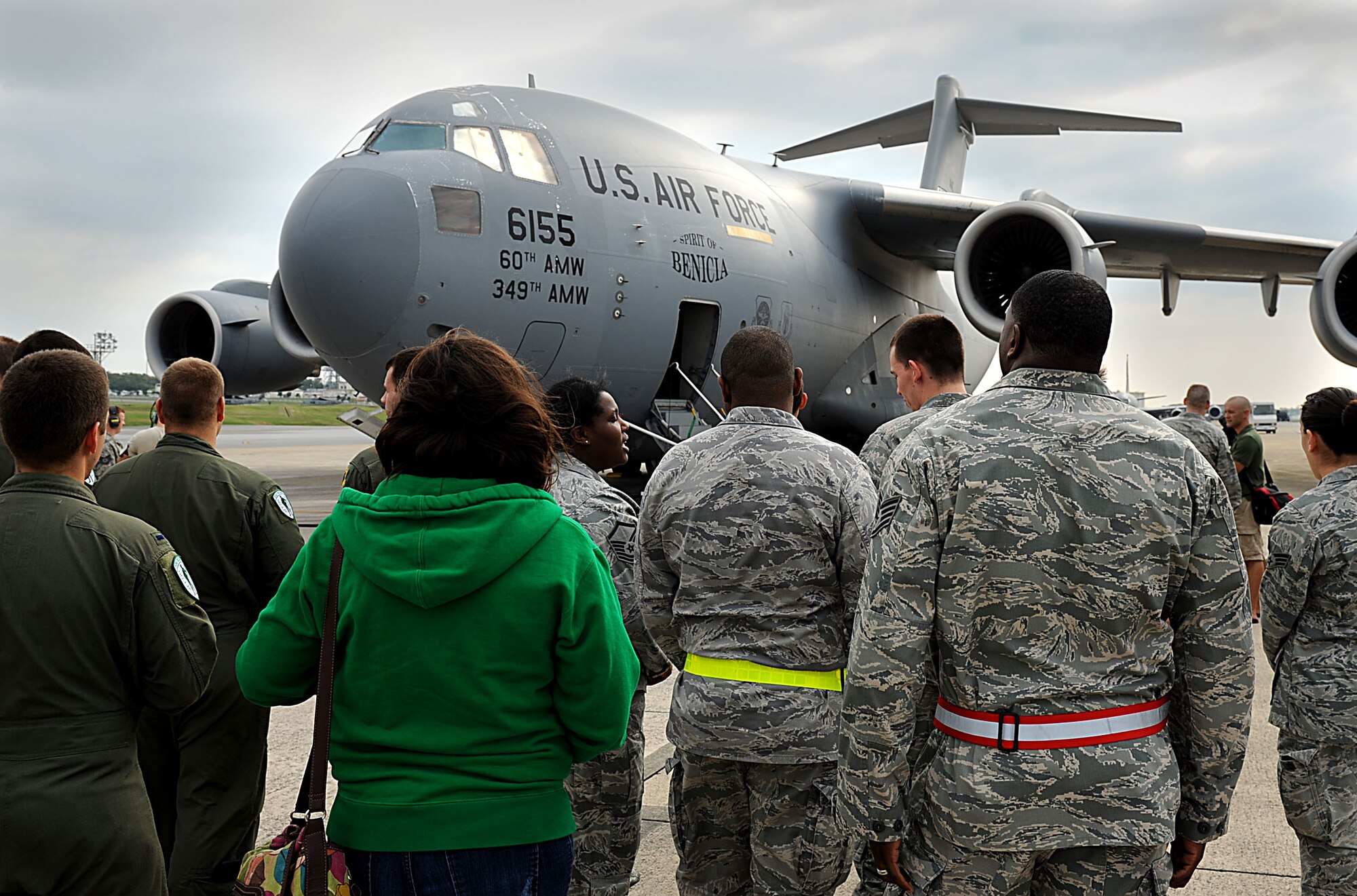 Members of the 33rd Rescue Squadron along with family and friends of U.S. Air Force Tech. Sgt. James Davis, 33rd Rescue Squadron flight engineer, wait for him to come down from a U.S. Air Force C-17 Globemaster III cargo plane on Kadena Air Base, Japan, Oct. 26. Davis is returning home to Kadena from Travis Air Force Base, Calif. after spending several months in rehabilitation for a gunshot wound he acquired while serving in Afghanistan this spring. (U.S. Air Force photo/Airman 1st Class Brooke P. Beers/Released)