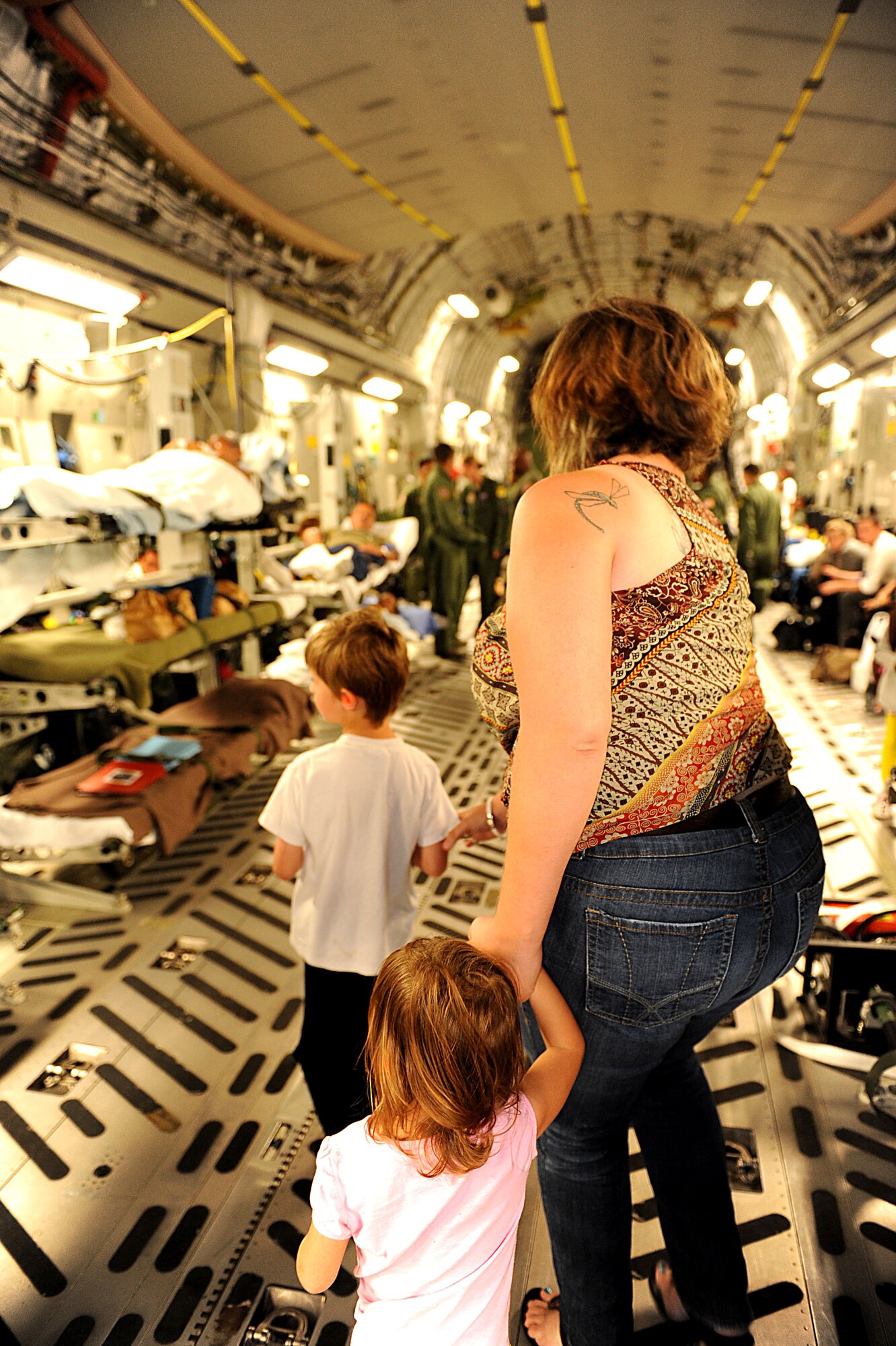 U.S. Air Force Tech. Sgt. James Davis’s family searches for him in a U.S. Air Force C-17 Globemaster III cargo plane on Kadena Air Base, Japan, Oct. 26. Davis is a flight engineer from the 33rd Rescue Squadron and is returning home after spending several months in rehabilitation for a gunshot wound he acquired while serving in Afghanistan this spring. (U.S. Air Force photo/Airman 1st Class Brooke P. Beers/Released)