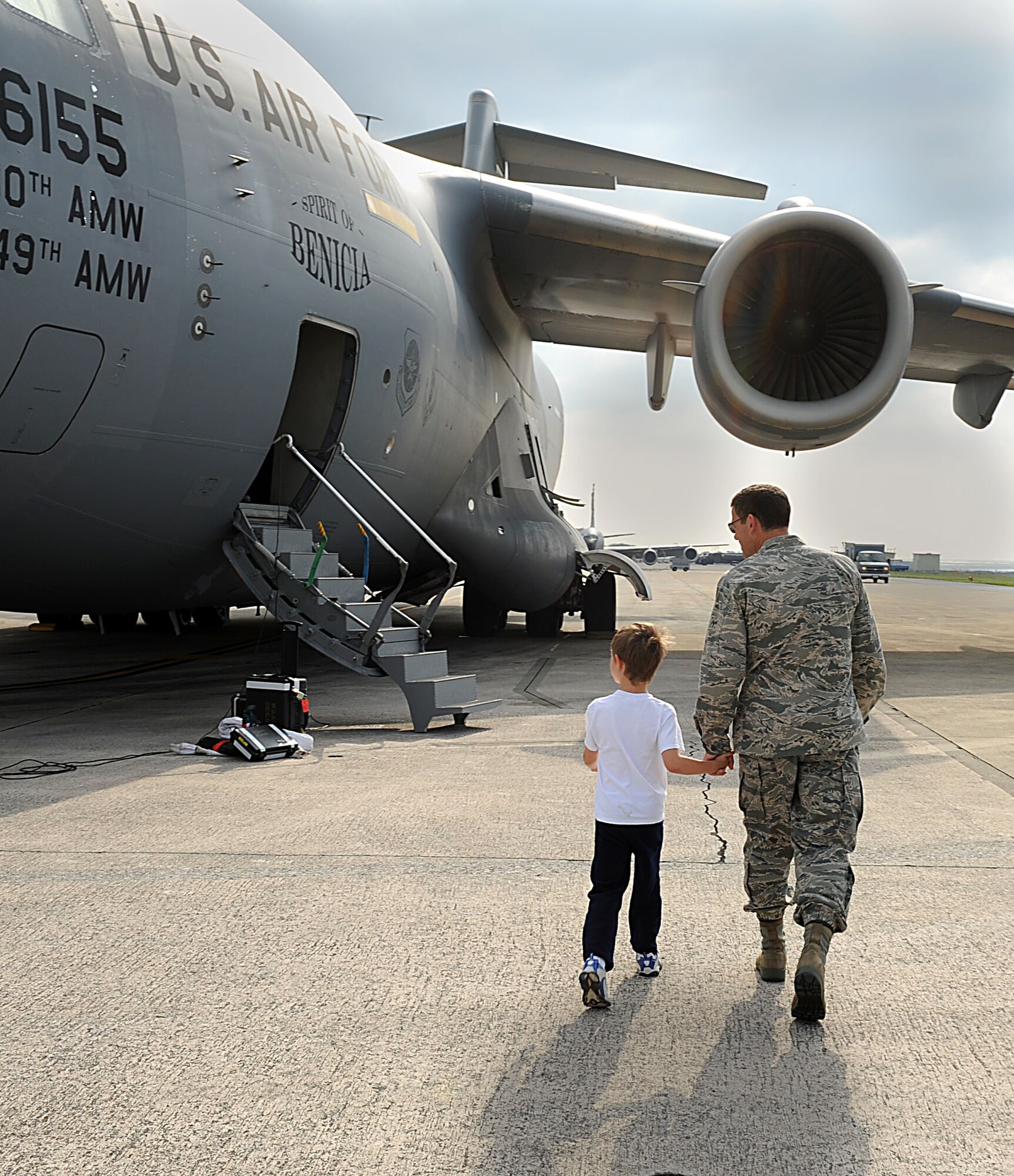 U.S. Air Force Brig. Gen. Matt Molloy,  18th Wing commander, walks with U.S. Air Force Tech. Sgt. James Davis’s son to a U.S. Air Force C-17 Globemaster III cargo plane on Kadena Air Base, Japan, Oct. 26. Davis is a flight engineer from the 33rd Rescue Squadron returning home to Kadena from Travis Air Force Base, Calif. after spending several months in rehabilitation for a gunshot wound he acquired while serving in Afghanistan this spring. (U.S. Air Force photo/Airman 1st Class Brooke P. Beers/Released)