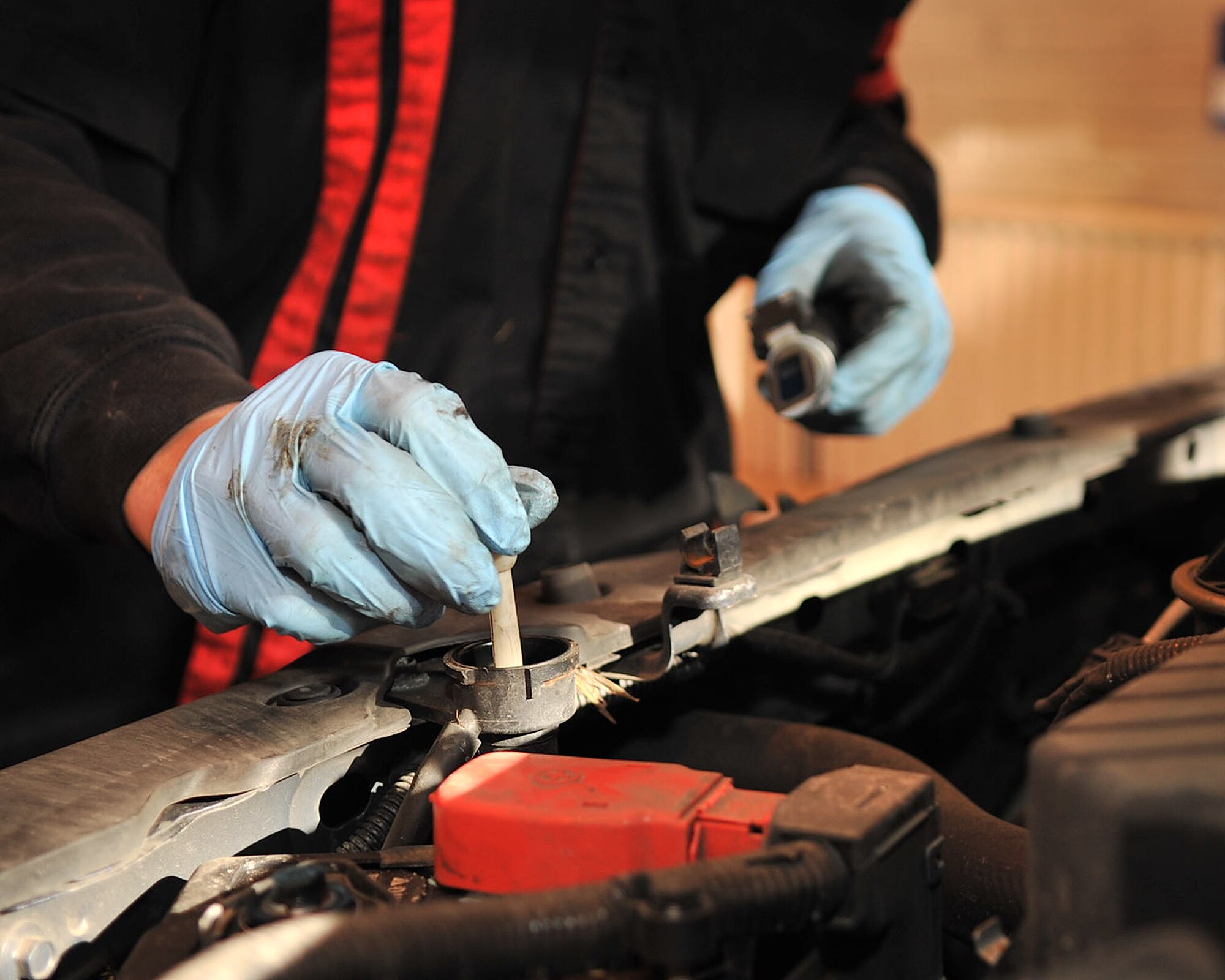 RAF MILDENHALL, England – Brian Muse, 100th Force Support Squadron Auto Hobby Complex mechanic, checks the anti-freeze levels of a car here Oct. 25, 2011. Before the winter months arrive, it’s recommended for vehicle operators to “winterize” their car by checking tires and tire pressure, making sure anti-freeze levels are good and windshield wipers are in proper working condition. (U.S. Air Force photo/Senior Airman Jerilyn Quintanilla)    