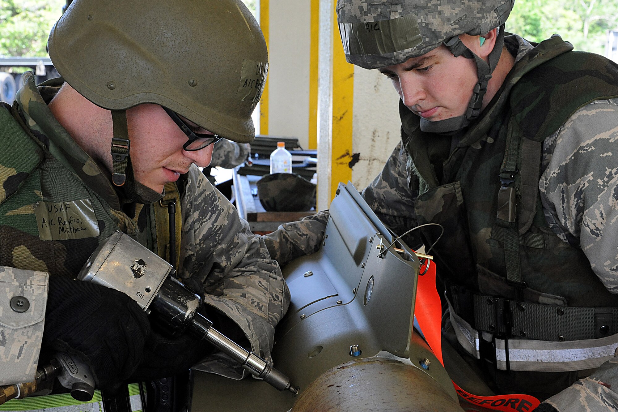 U.S. Air Force Airman 1st Class Matthew Renfro, 18th Maintenance Group, crew member, secures the tail to the rest of the bomb during local operational readiness exercise Beverly High 12-1, on Kadena Air Base, Japan, Oct. 26. Beverly High is an exercise designed to test the 18th Wing's combat readiness to defend Japan and provide stability within the region. (U.S. Air Force photo/Airman 1st Class Justin Veazie/released)