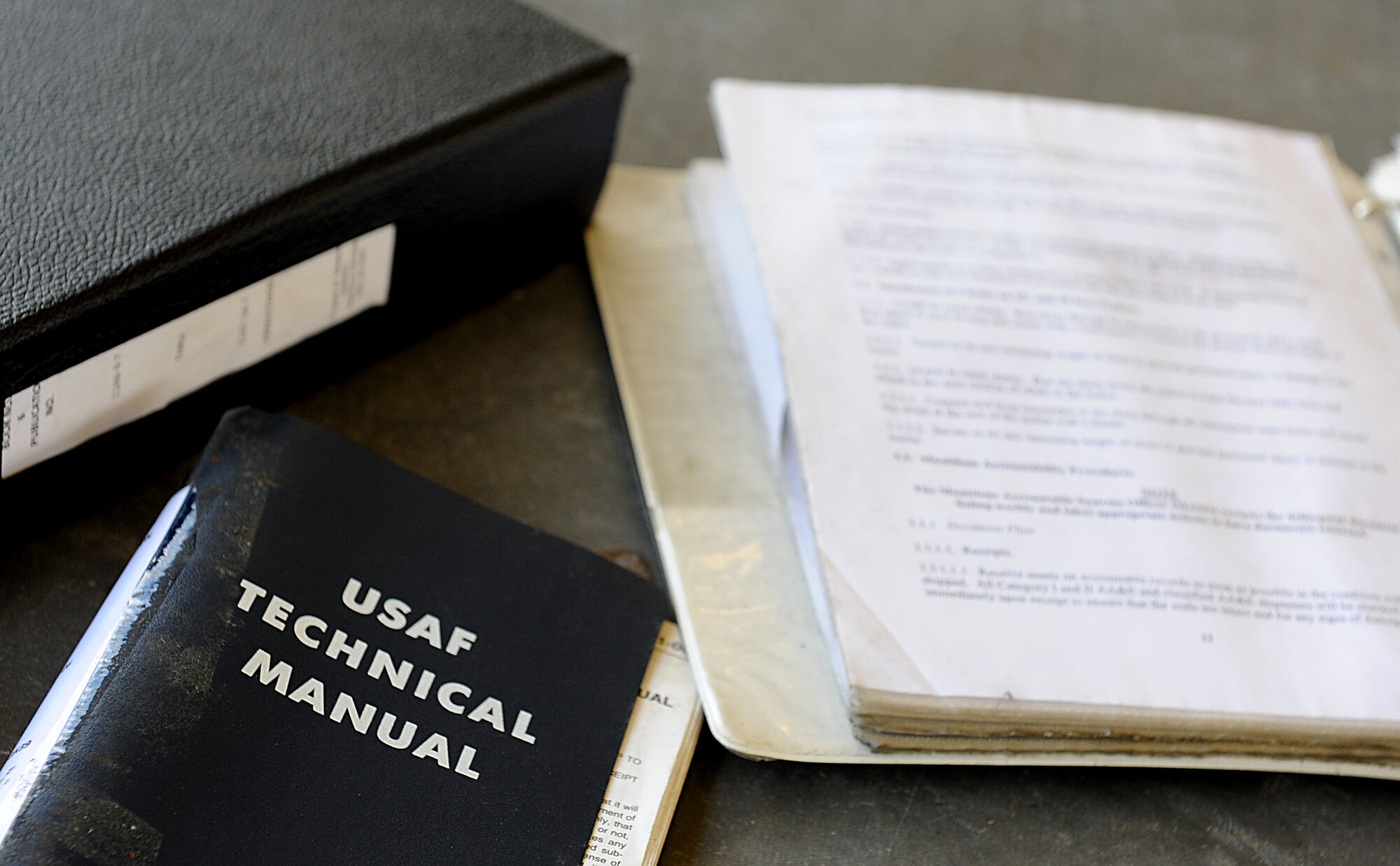 A U.S. Air Force technical manual sits a few feet away from the Airmen of the 18th Munitions Squadron while they work on generating bombs for local operational readiness exercise Beverly High 12-1 on Kadena Air Base, Japan, Oct. 26. The Airmen of the MUNS  don’t normally make bombs every day, so they take the time during the exercise to train for potential real-world contingencies. (U.S. Air Force photo/ Airman 1st Class Brooke P. Beers/released)
