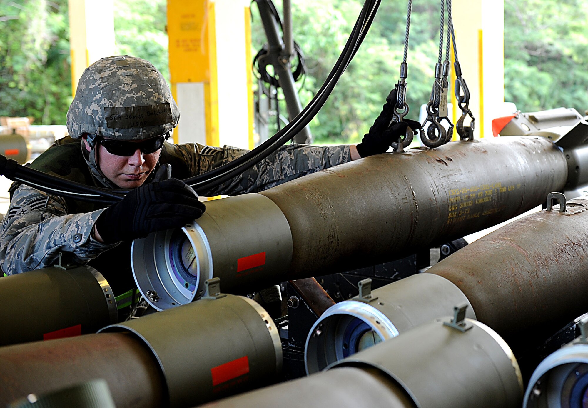 U.S. Air Force Senior Airman James Bulchus, 18th Munitions Squadron munitions inspector, lowers a bomb onto a trailer during local operational readiness exercise Beverly High 12-1 on Kadena Air Base, Japan, Oct. 26. The MUNS Airmen support Kadena's two F-15 fighter squadrons, the 44th and 67th, as well as the 33rd Rescue Squadron and 353rd Special Operations Group. (U.S. Air Force photo/ Airman 1st Class Brooke P. Beers/released)