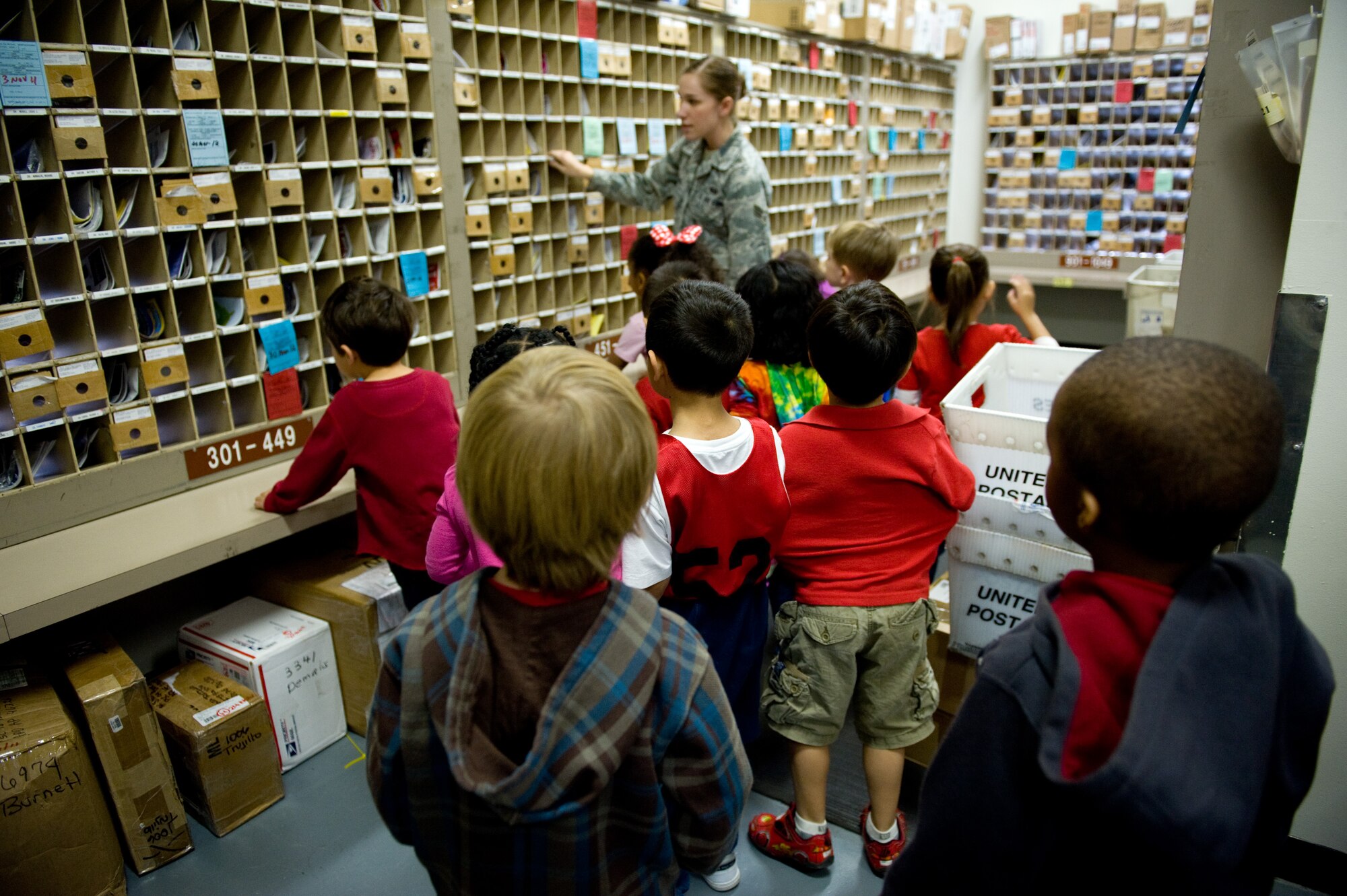 YOKOTA AIR BASE, Japan -- Senior Airman Erica Heal, 374th Communications Squadron military postal clerk, shows kindergarten students, from Yokota's West Elementary School, their parents' mailboxes at Yokota Air Base, Japan, Oct. 26, 2011. Kindergarten students from Yokota West Elementary School visited the post office to get a better understanding of how the mail system works. (U.S. Air Force photo/Airman 1st Class Krystal M. Garrett) 
  
