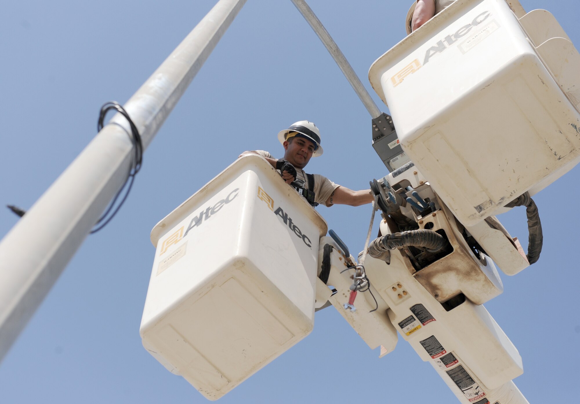 Staff Sgt. Hector Guardado, an electrical systems craftsman with the 380th Expeditionary Civil Engineer Squadron, receives a crescent wrench while installing a solar street light in the munitions storage area at the 380th Air Expeditionary Wing Oct. 17, 2011. The engineers will install 24 energy efficient solar lights that will provide fossil fuel savings while also enabling fixed lighting in an area of the base that is not connected to the energy grid. (U.S. Air Force photo/Master Sgt. Chance Babin)
