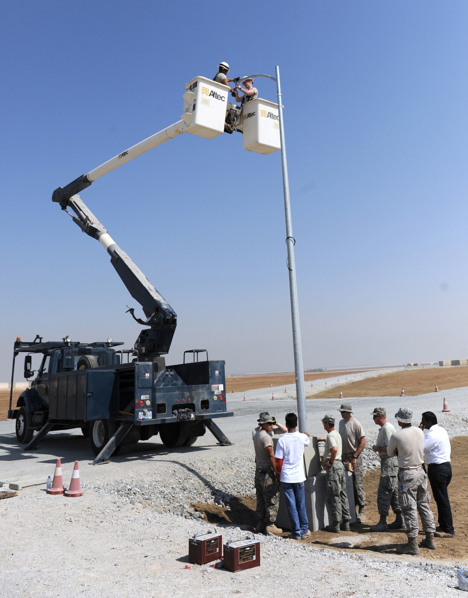 A group of 380th Expeditionary Civil Engineer Squadron members installs a solar light in the munitions storage area of the 380th Air Expeditionary Wing Oct. 17, 2011. The engineers will install 24 energy efficient solar lights that will provide fossil fuel savings while also enabling fixed lighting in an area of the base that is not connected to the energy grid.  (U.S. Air Force photo/Master Sgt. Chance Babin)