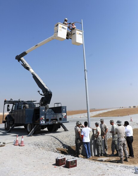 A group of 380th Expeditionary Civil Engineer Squadron members installs a solar light in the munitions storage area of the 380th Air Expeditionary Wing Oct. 17, 2011. The engineers will install 24 energy efficient solar lights that will provide fossil fuel savings while also enabling fixed lighting in an area of the base that is not connected to the energy grid.  (U.S. Air Force photo/Master Sgt. Chance Babin)