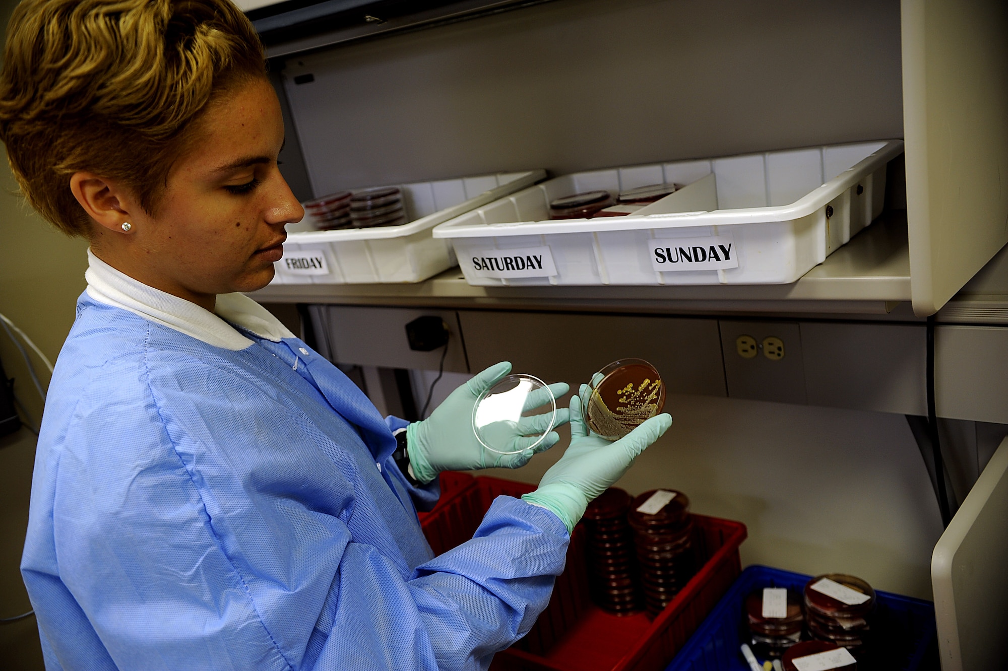 U.S. Air Force Senior Airman Taniah Otis, 18th Medical Support Squadron laboratory technician, looks at a bacteria culture on a chocolate agar Oct. 25 on Kadena Air Base, Japan. The two main types of agars used at Kadena are blood and chocolate, both of which allow bacteria to grow quickly. (U.S. Air Force photo/Staff Sgt. Christopher Hummel/released)