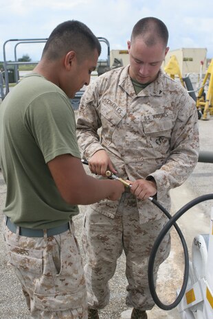 Cpl. Jose L. Beas (left) and Lance Cpl. Joseph S. Charles, Marine Aviation Logistic Squadron 12 cryogenic technicians,::r::::n::connect the hose of a pressurized nitrogen cart to the cart body at the flightline here Oct. 26.