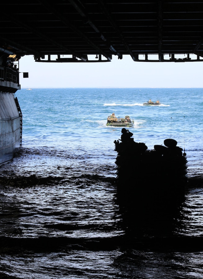 USS IWO JIMA (LHD 7) – Assault Amphibian vehicle (AAV) crewmen from 2nd Assault Amphibian Vehicle platoon, Battalion Landing Team 1st Battalion, 2nd Marine Regiment, 24th Marine Expeditionary Unit  make their way to the well deck of the amphibious assault ship USS Iwo Jima, from the USS New York Oct. 26, 2011. The AAV’s practiced loading and off loading from the Iwo Jima as part of the Amphibious Squadron 8 (PHIBRON 8)/ MEU Integration Exercise, known as PMINT. PMINT will take place Oct. 24 to Nov. 3 and is focused on building the Navy-Marine Team and establishing the working relationships and practices necessary to conduct operations from the sea. (Official USMC Photo by: Lance Cpl Michael J. Petersheim/ Released)