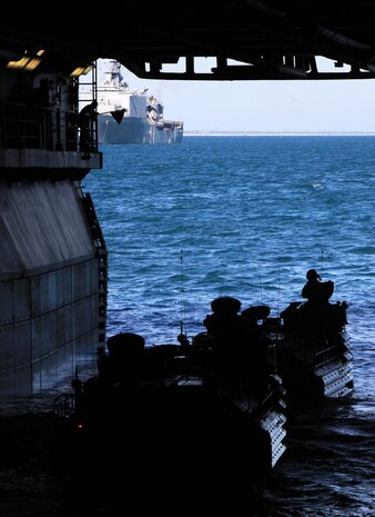 USS IWO JIMA (LHD 7) – Assault Amphibian Vehicle (AAV) crewmen from 2nd Assault Amphibian Vehicle platoon, Battalion Landing Team 1st Battalion, 2nd Marine Regiment, 24th Marine Expeditionary Unit prepare to off load from the well deck of the amphibious assault ship USS Iwo Jima Oct. 26, 2011. The crewmen practiced loading and off loading their AAV’s from the USS Iwo Jima as part of the Amphibious Squadron 8 (PHIBRON 8)/ MEU Integration Exercise, known as PMINT.  The AAV’s also loaded onto the USS New York and USS Gunston Hall, the other two ships that make up PHIBRON 8.  PMINT will take place Oct. 24 to Nov. 3 and is focused on building the Navy-Marine Team and establishing the working relationships and practices necessary to conduct operations from the sea. (Official USMC Photo by: Lance Cpl Michael J. Petersheim/ Released)