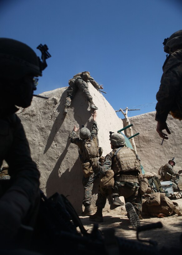 A Marine with 2nd Platoon, Bravo Company, 1st Battalion, 6th Marine Regiment, prepares to jump down from a rooftop after being shot at during Operation Eastern Storm. The Marines and sailors of Bravo Co. are participating in the operation to clear insurgents along Route 611 from Sangin to Kajaki. Driving out insurgents along the route will make it safe for coalition forces and local citizens traveling to the district center in Sangin.