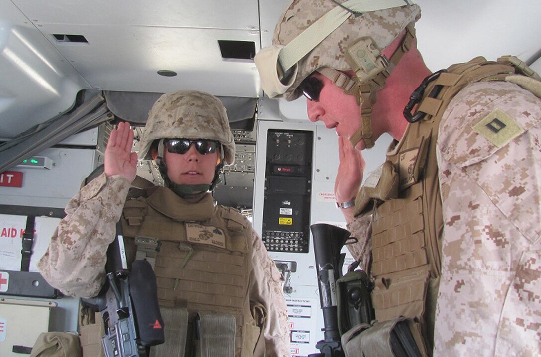 Sgt. Jennifer Chitwood, an administration specialist with Headquarters and Service Company, 2nd Marine Logistics Group (Forward), raises her right hand as she states her re-enlistment oath aboard an aircraft above Helmand province, Afghanistan, Oct. 27. Chitwood decided to re-enlist with the intention of becoming a drill instructor. (Courtesy Photo)