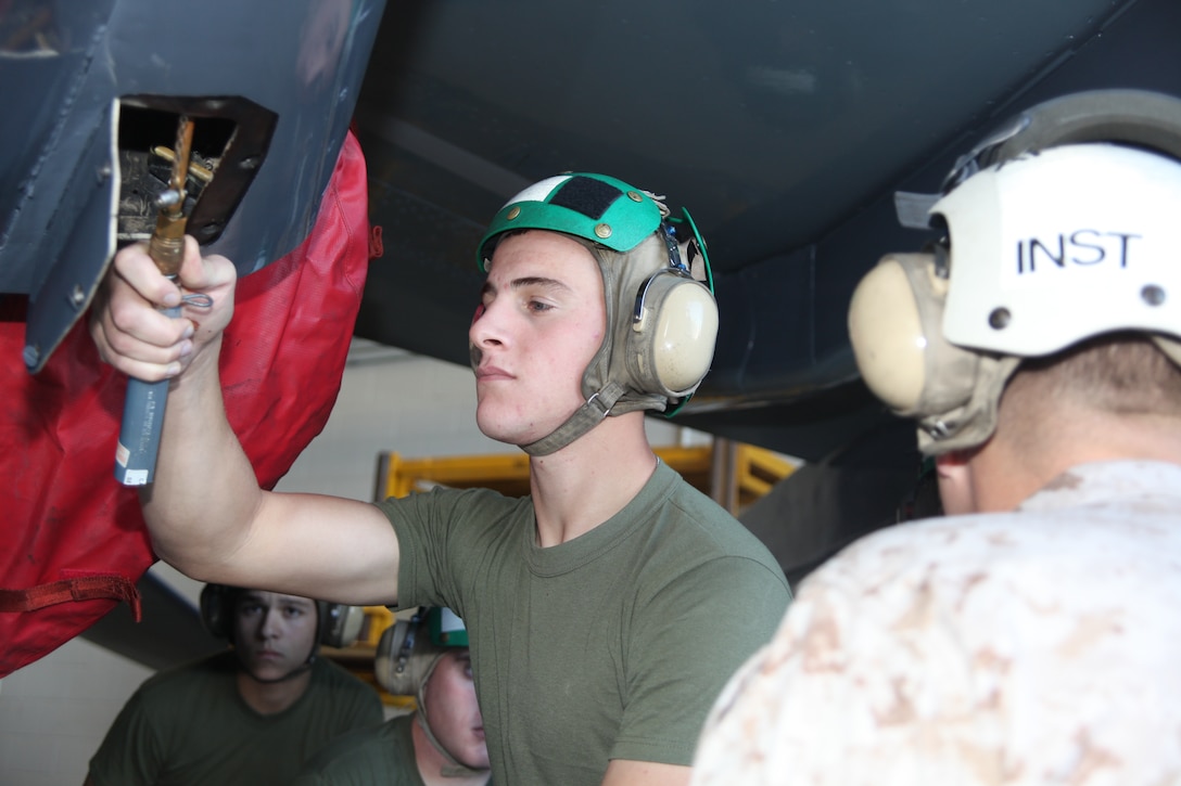 Pfc. Tyler J. Skinner, a student with the Center for Naval Aviation Technical Training , takes a pressure reading on the school's AV-8B Harrier Maintenance Trainer during a class on proper hydraulic servicing given by Gunnery Sgt. Jeremiah W. Francis, the course supervisor for the AV-8B organixational level airframes at CNATT Oct. 27, 2011.