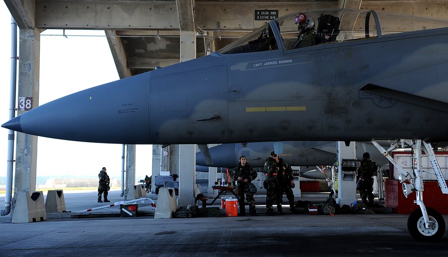 U.S. Air Force Colonel David Nahom, 18th Operations Group commander, prepares to taxi his F-15 Eagle as a crew of Airmen from the 18th Aircraft Maintenance Squadron look on during local operational readiness exercise Beverly High 12-1 Oct. 28, on Kadena Air Base, Japan. Although crew chiefs and other maintenance personnel are generating sorties, they are still required to wear the appropriate protective gear during the LORE. (U.S. Air Force photo/Staff Sgt. Christopher Hummel/released)