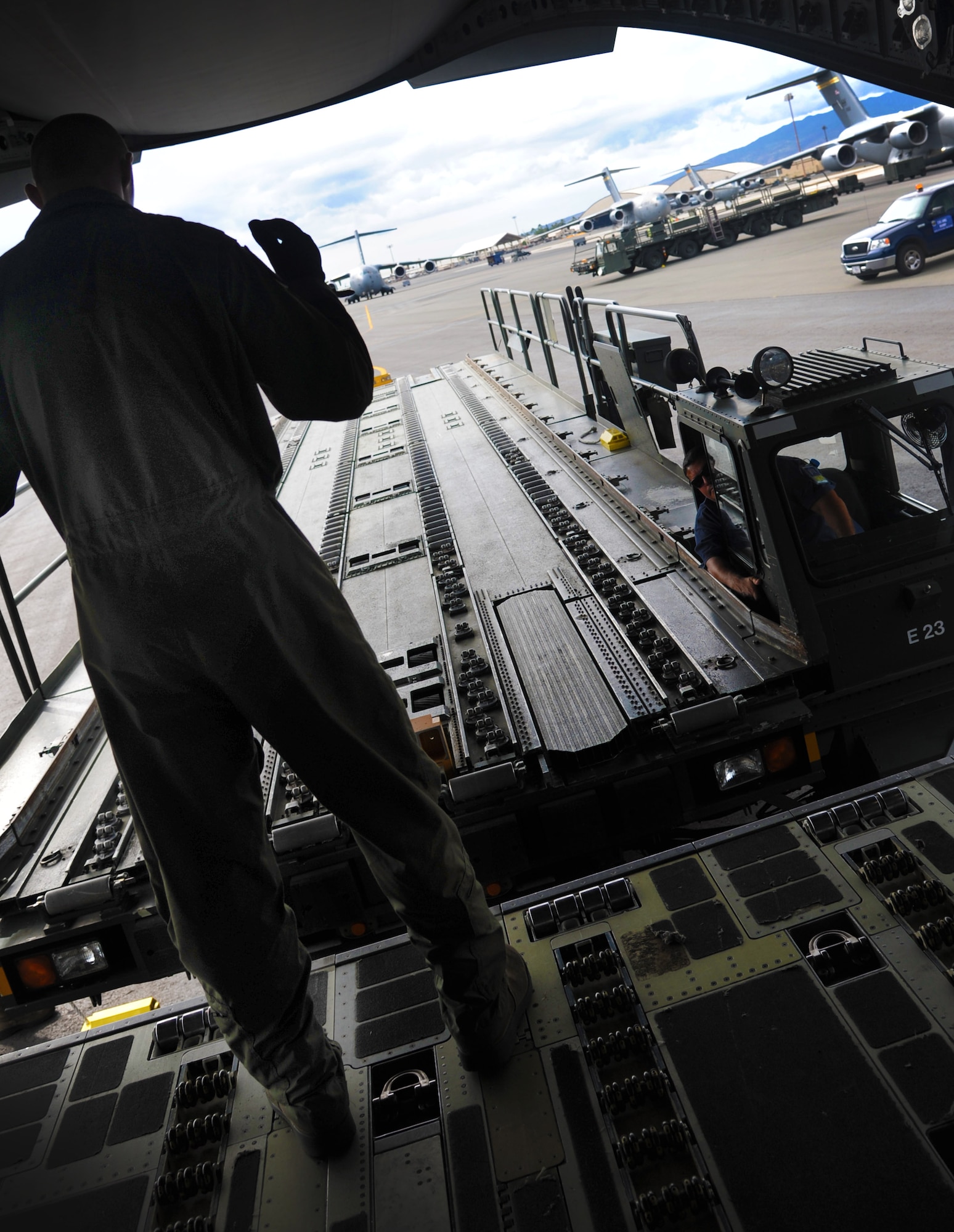 Airman 1st Class Caleb Williams, loadmaster with the 535th Airlift Squadron, marshalls a k-loader towards the ramp of a C-17 Globemaster III on Joint Base Pearl Harbor-Hickam, Hawaii, Oct. 27. The cargo off loaded was part of an Operational Readiness Exercise held to ensure the Airmen and agencies are ready to support the mission and ensure seamless integration of installation support into the 15th Wing's combat mission execution.(U.S. Air Force photo/Senior Airman Lauren Main)