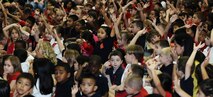 ANDERSEN AIR FORCE BASE, Guam—Children from Andersen Elementary School raise their hands during a drug prevention assembly here, Oct. 25. After the assembly, children from the elementary school were asked to pledge that they would remain drug free throughout their lives. (U.S. Air Force photo by Senior Airman Benjamin Wiseman/Released)
