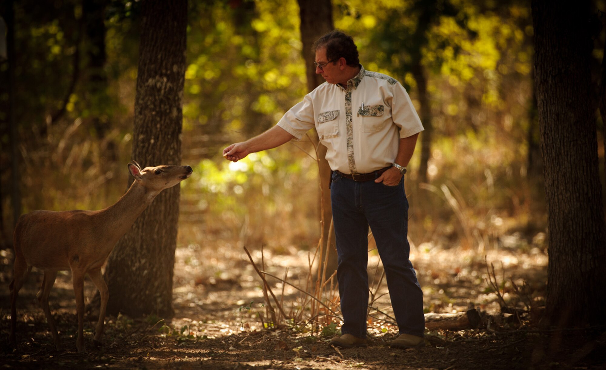 HEAD HUNTER - At his 11-acre ranch in Seguin, Texas, Hahn feeds one of the 13 whitetail deer he is raising — partly as a hobby and for future sale. (photo by Tech. Sgt. Samuel Bendet)