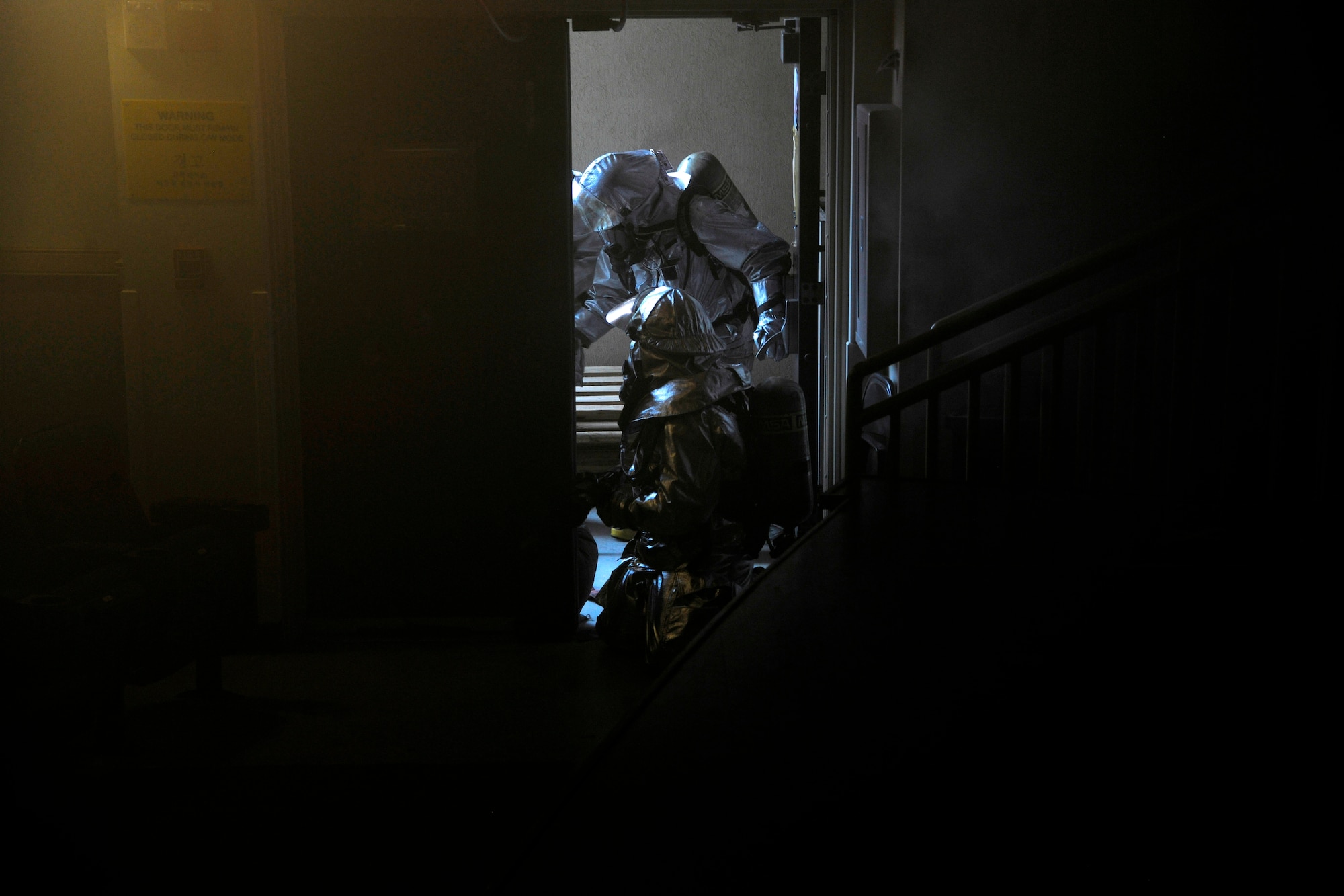 Firefighters from the 8th Civil Engineer Squadron clear out the base theater to check for causalities during a scenario in which the Exercise Evaluation Team said the base theater's curtains caught on fire at Kunsan Air Base, Republic of Korea, Oct. 24, 2011. The EET's scenarios included a full spectrum of events, keeping the wing fully engaged around the clock as maintainers launched aircraft, security forces defended the base and firefighters responded to a multitude of emergency situations. (U.S. Air Force photo by Staff Sgt. Rasheen Douglas/Released)