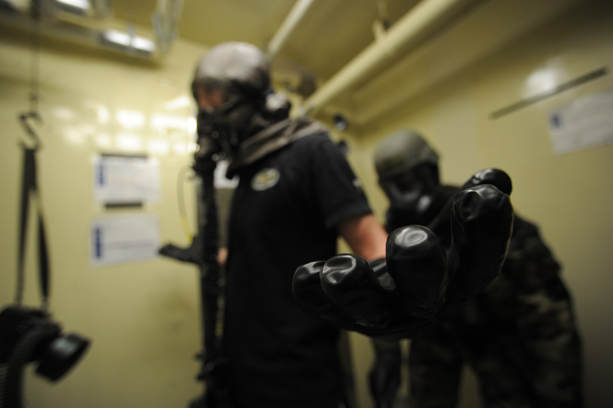 Capt. John Powers, 80th Fighter Squadron pilot, receives help from Senior Airman Jeffrey Wurst, 8th Operations Support Squadron aircrew flight equipment technician, in getting out of his decontaminated clothing during a simulated scenario of decontaminating a pilot at Kunsan Air Base, Republic of Korea, Oct. 24, 2011. The Exercise Evaluation Team scenarios included a full spectrum of events, keeping the wing fully engaged around the clock as maintainers launched aircraft, security forces defended the base and firefighters responded to a multitude of emergency situations. (U.S. Air Force photo by Staff Sgt. Rasheen Douglas/Released)