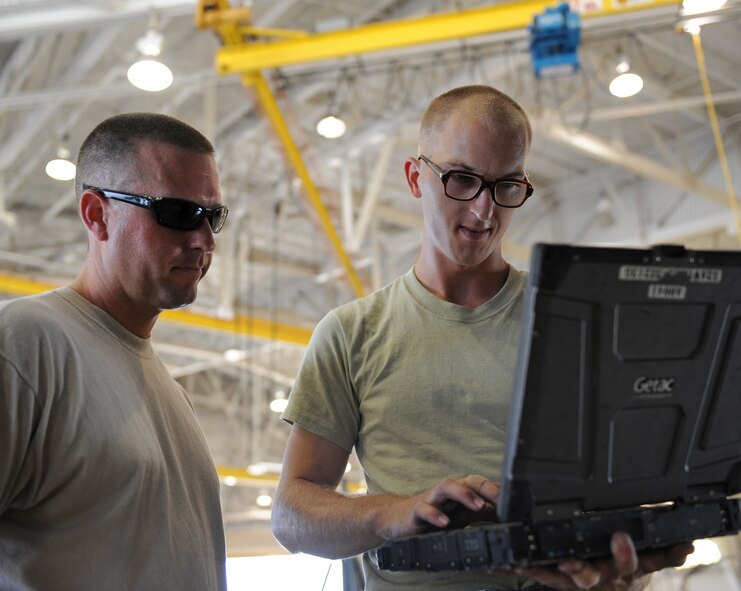 Tech. Sgt. Christian Davis, 2nd Aircraft Maintenance Squadron, watches as Staff Sgt. Paul McKinley, 2 AMXS, looks up technical orders on a laptop on Barksdale Air Force Base, La., Oct. 25. Davis and several other Airmen were preparing to move a B-52H Stratofortress into position on the ramp. (U.S. Air Force photo/Airman 1st Class Micaiah Anthony)(RELEASED)