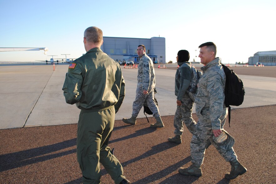 MALMSTROM AIR FORCE BASE, Mont. - Capt. Bill Dyer, left, escorts incentive flight riders; Staff Sgt. Kyle Baker, 341st Missile Maintenance Squadron critical task supervisor; Senior Airman Anastasia Miller, 341st Operations Support Squadron/accounting apprentice; and Tech. Sgt. Scott Devore, 12th Missile Squadron facility manager; to the Navy E-6B mobile command post, or airborne platform. Dyer, from the 625th Strategic Operations Squadron in Offut AFB, Neb., was a crew member on the flight Oct. 18. (U.S. Air Force photo/Airman Cortney Paxton)