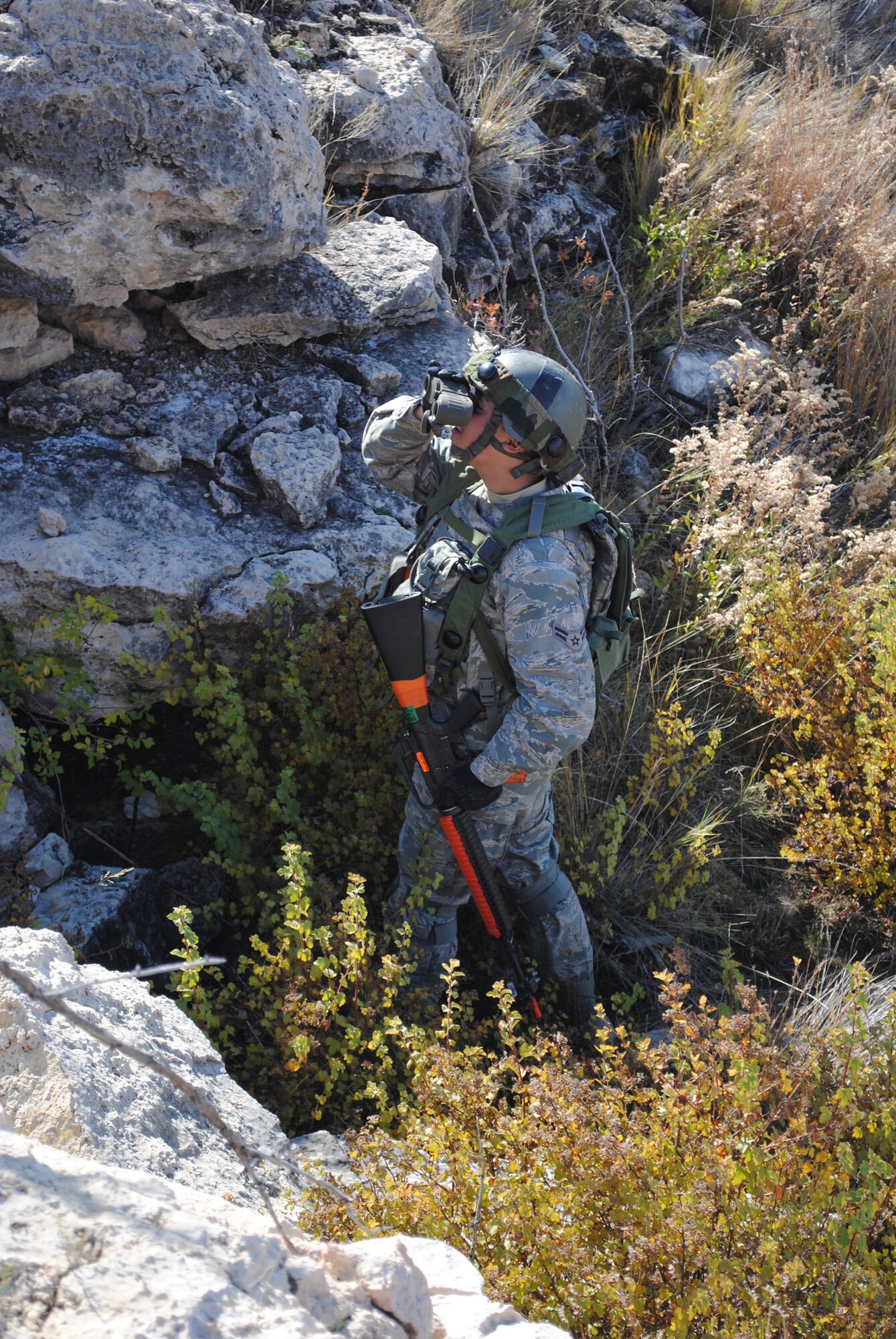 Airman 1st Class Alberto Sevilla, convoy response force member with the 741st Missile Security Forces Squadron, uses binoculars to see if members of his team are being followed by the opponent at Camp Guernsey. (U.S. Air Force photo/Airman 1st Class Katrina Heikkinen)