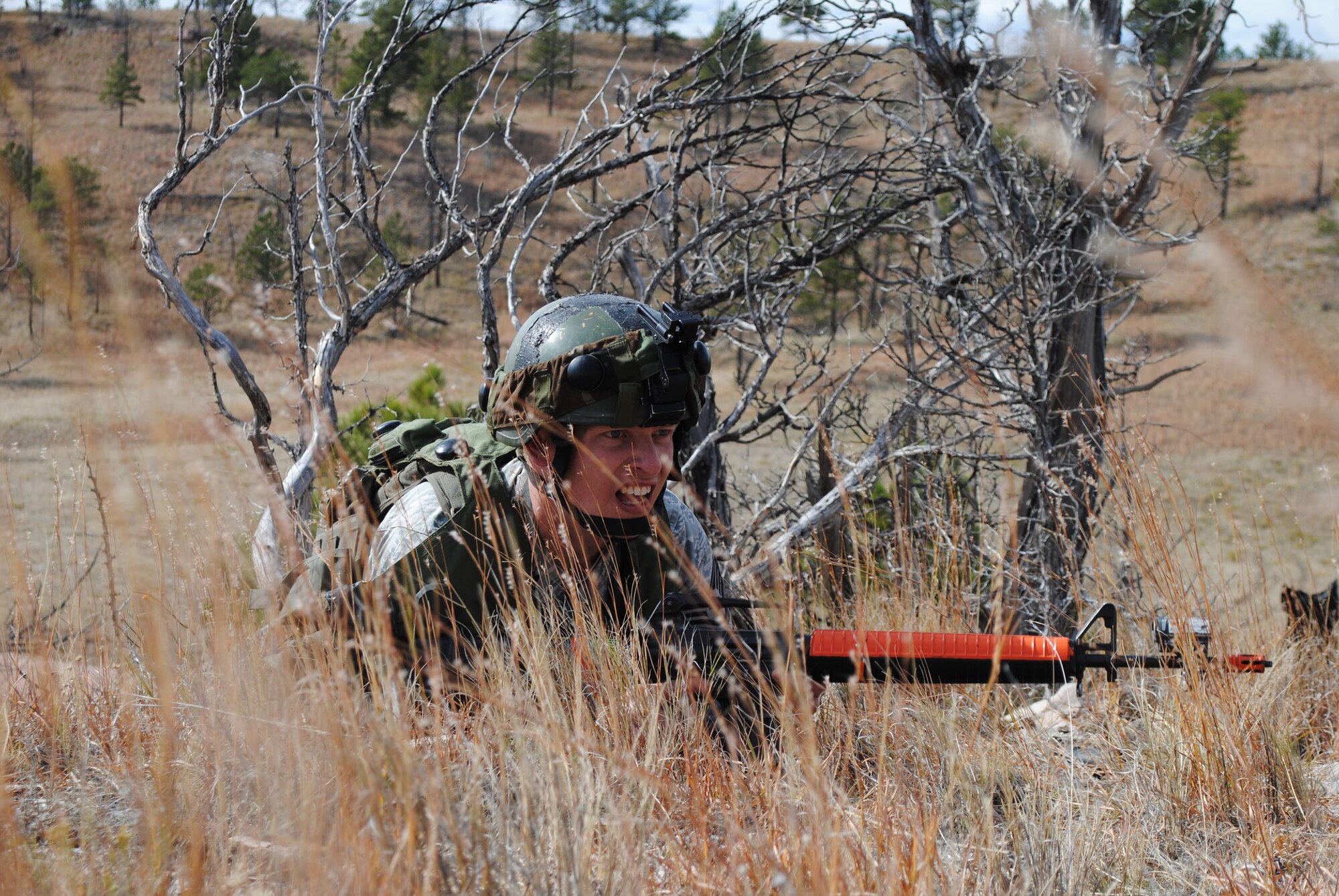 Staff Sgt. Thomas Andrews, convoy response force member with the 741st Missile Security forces Squadron, remains hidden in the grass while keeping a close eye on Op For, the opposing team. (U.S. Air Force photo/Airman 1st Class Katrina Heikkinen)