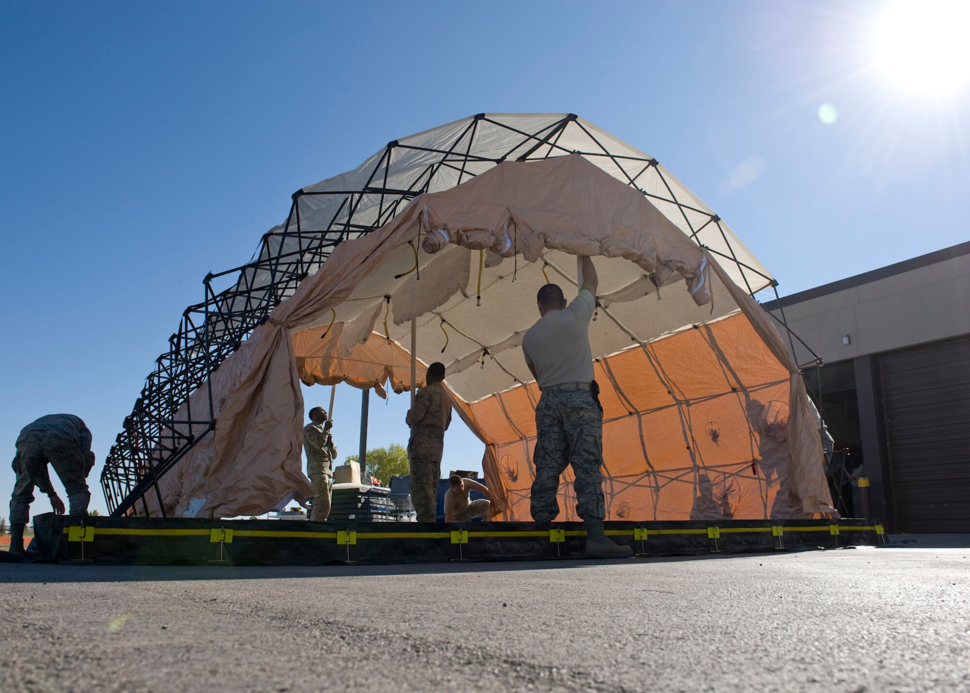 Members of the 28th Medical Group construct a decontamination tent during a Chemical, Biological, Radiological, Nuclear and Explosives major accident response exercise at Ellsworth Air Force Base, S.D., Oct. 21, 2011. Victims with simulated contamination were brought into the tent to be decontaminated, which provided medical personnel the opportunity to train to properly utilize the tent and save lives. (U.S. Air Force photo by Airman 1st Class Kate Thornton/Released)