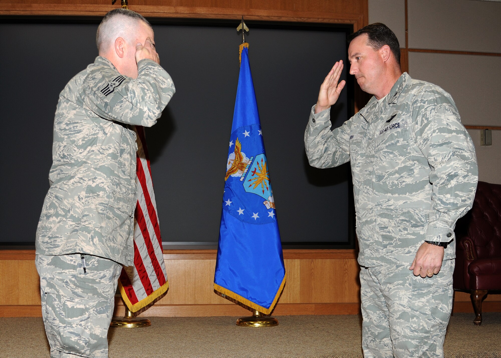 U.S. Air Force Col. Tim Bush, 319th Air Base Wing commander, (right) salutes Staff Sgt. Bryant Martin, 319th Security Forces Squadron, after presenting him with a commander’s coin on Oct. 26 at Grand Forks Air Force Base, N.D. Bryant is credited with helping a 5-year-old base family member who stopped breathing during a seizure on base Oct. 23. (U.S. Air Force photo/Airman 1st Class Ashley Taylor)