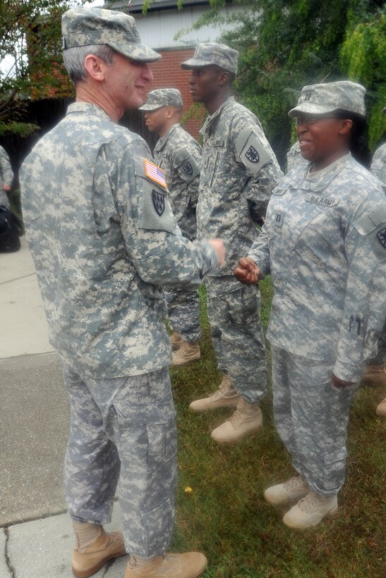 Lt. Gen. Howard B. Bromberg, (left) deputy commanding general and chief of staff, Forces Command, presents a coin to Capt. Lolita Waverly, (right) 7th Sustainment Brigade (Provisional) medical operations officer in charge, for exceptional duty performance outside the brigade's headquarters building Oct. 19.(U.S. Army photo by Sgt 1st. Class Kelly Jo Bridgwater/RELEASED)