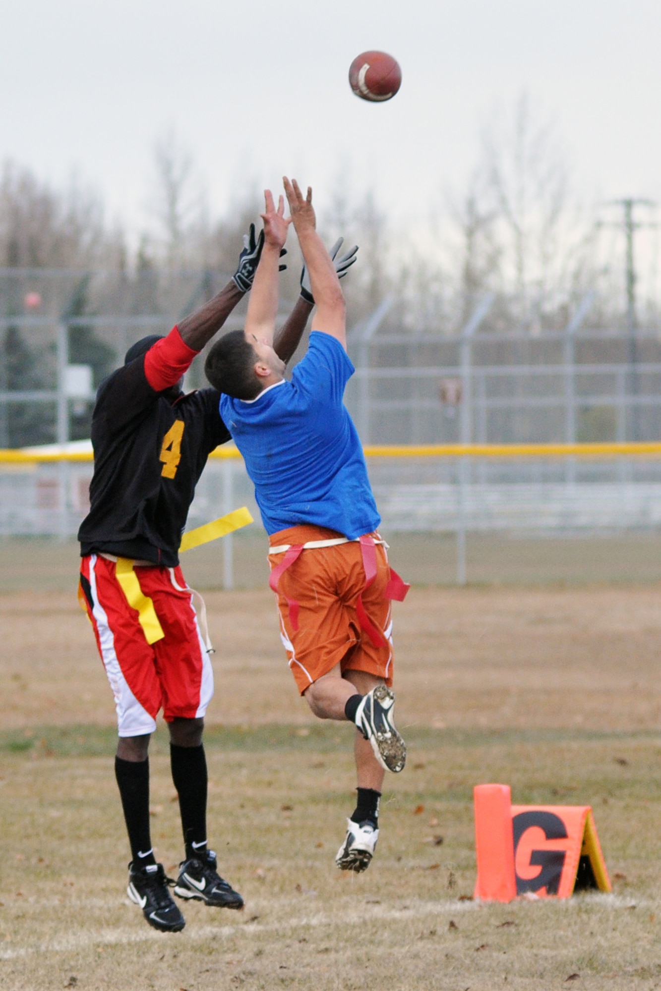 Rich Pantoja (blue shirt) turns defender for the 3rd Equipment Maintenance Squadron against 56th Engineer Company?s Victor Robinson to intercept a last-chance scoring attempt in the 4th quarter of the championship game Saturday at the Buckner Physical Fitness Center field. (U.S. Air Force photo/John Pennell)