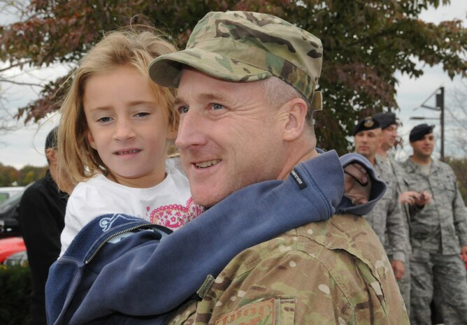 Master Sgt. Joseph Ahearn, 166th Security Forces Squadron, Delaware Air National Guard, reunites with a family member on Oct. 21, 2011 after completing a six-month combat-zone mission in Afghanistan in support of Operation Enduring Freedom. Thirteen members of the 166th SFS returned home together to the New Castle ANG Base, Del. (U.S. Air Force photo/Tech. Sgt. Harold Herglotz)