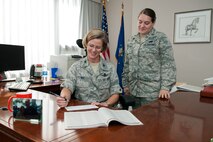 HANSCOM AIR FORCE BASE, Mass. – Col. Stacy L. Yike, 66th Air Base Group commander, sorts through the charities lists and signs a pledge card for the Combined Federal Campaign as 2nd Lt. Jessica Zencey, CFC installation manager, stands by. Hanscom’s CFC, which has already raised $41,000 toward a goal of $315,000, will continue until Nov. 23. (U.S. Air Force photo by Rick Berry)