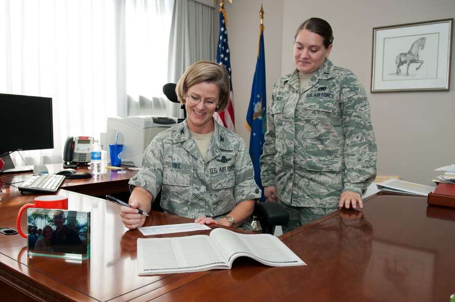 HANSCOM AIR FORCE BASE, Mass. – Col. Stacy L. Yike, 66th Air Base Group commander, sorts through the charities lists and signs a pledge card for the Combined Federal Campaign as 2nd Lt. Jessica Zencey, CFC installation manager, stands by. Hanscom’s CFC, which has already raised $41,000 toward a goal of $315,000, will continue until Nov. 23. (U.S. Air Force photo by Rick Berry)