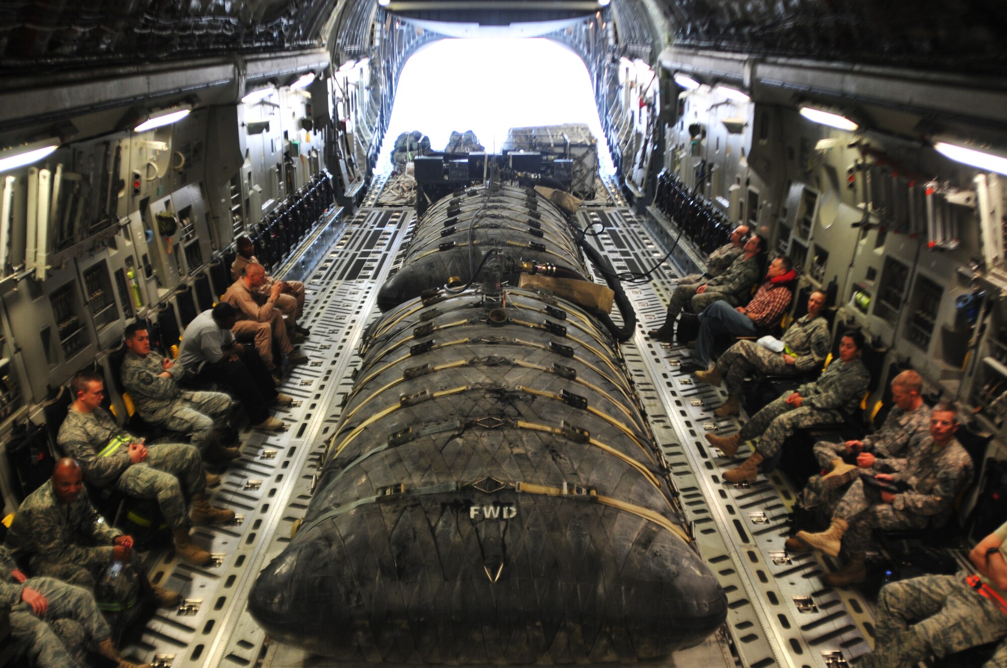 U.S. servicemembers from various branches hitch a ride on an aircraft carrying two fuel bladders filled with aviation gasoline Oct. 21, 2011, at an undisclosed location in Southwest Asia. The fuel bladders are self-sealing and can withstand small arms fire. (U.S. Air Force photo/Senior Airman Eric Summers Jr.)