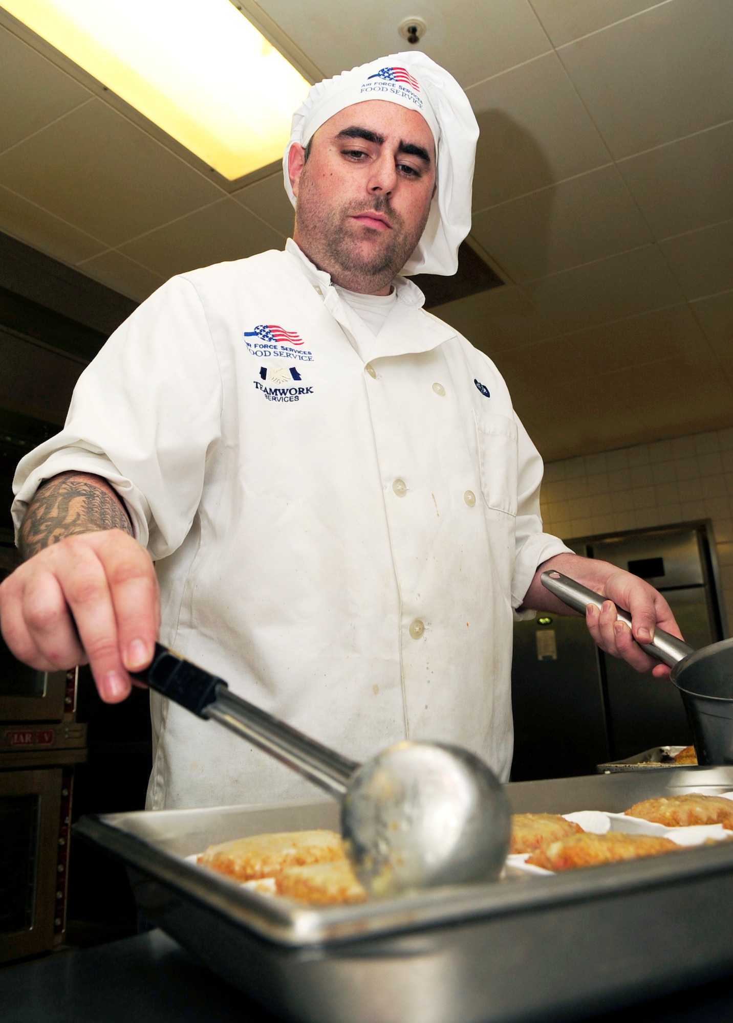 RAF MILDENHALL, England – Rob Walker, 100th Force Support Squadron cook, pours garlic butter on freshly baked stuffed fish for dinner at the Gateway Dining Facility here Oct. 25, 2011. Dinner is served at the dining facility from 4 to 6:30 p.m. weekdays and 4 to 6 p.m. weekends. (U.S. Air Force photo/Senior Airman Ethan Morgan)
