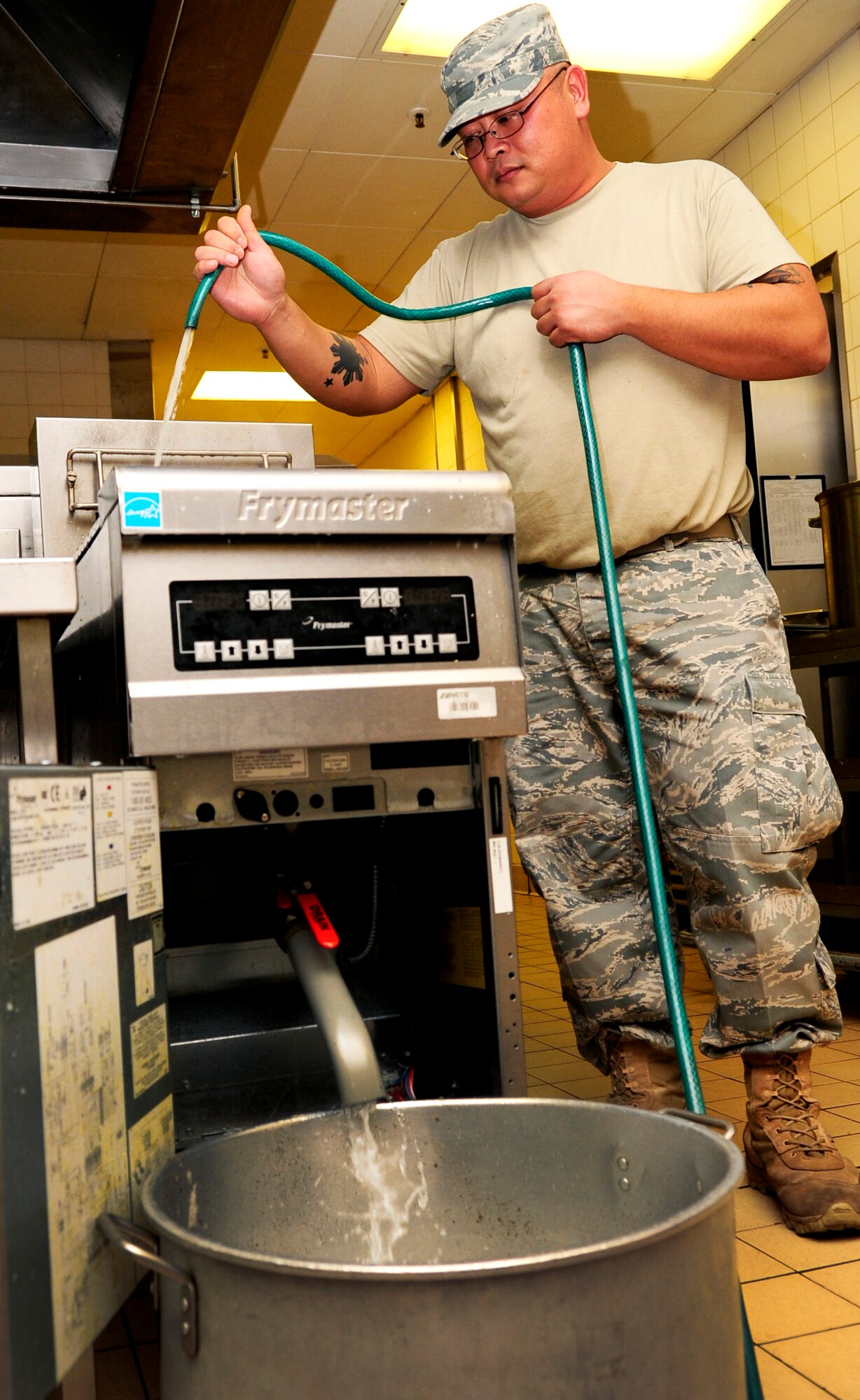 RAF MILDENHALL, England – Staff Sgt. Alexander Reynaldo, 100th Force Support Squadron Gateway Dining Facility morning-shift leader, washes out a deep fryer at the end of his shift at the Gateway Dining Facility here Oct. 25, 2011. The deep fryer is cleaned three times a day, before the beginning of each new shift. (U.S. Air Force photo/Senior Airman Ethan Morgan)