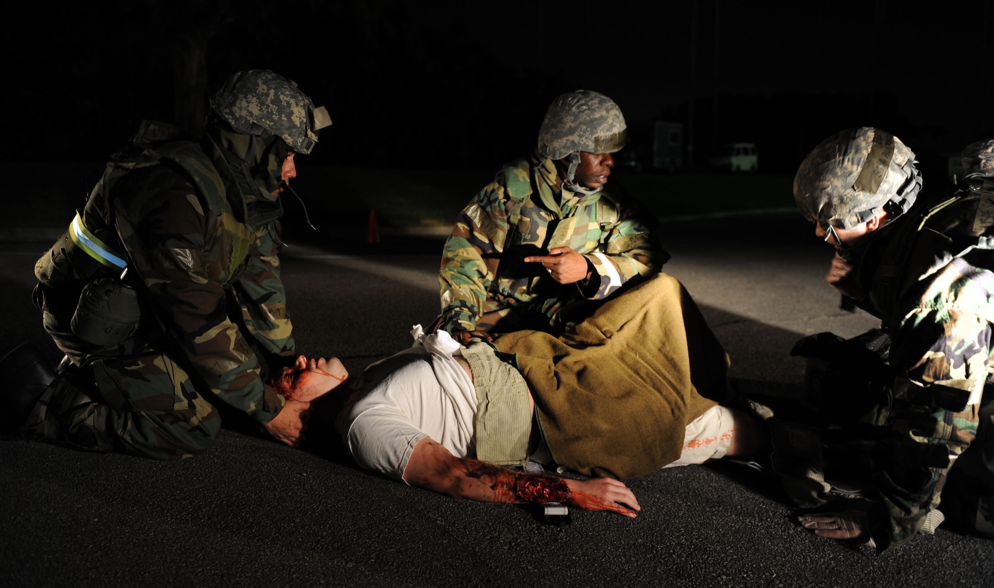 Airmen from the 18th Aeromedical Evacuation Squadron begin self-aid and buddy care on moulage victim U.S. Air Force Airman 1st Class Beau Shelley, 18th Equipment Maintenance Squadron armament apprentice, during local operational readiness exercise Beverly High 12-1 at Kadena Air Base, Japan, Oct. 26. Victims like Shelley add a sense of urgency and realism to exercise scenarios with their visible "wounds." U.S. Air Force photo/ Senior Airman Sara Csurilla/ released)