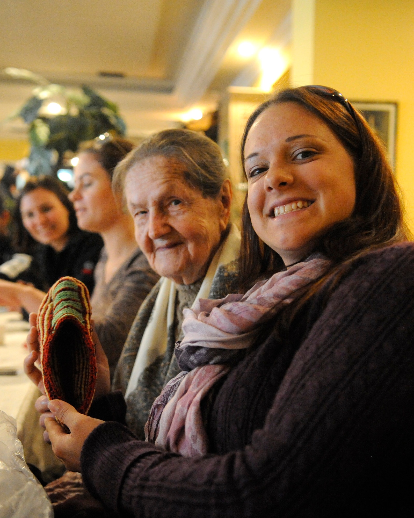 Staff Sgt. Brittany Lawson shows off a pair of socks that Mariya Kirichenko knitted for her during a lunch with three Babushkas in Bishkek, Kyrgyzstan, Oct. 25. Babushka is the Russian word for grandmother. Airmen at the Transit Center at Manas have volunteered more than 50,000 hours, which have been invested to Kyrgyz organizations and charities through the Manas Area Benefit Outreach Society since 2003. Lawson is deployed to the Transit Center as a 376th Expeditionary Operations Support Squadron weather forecaster from Eglin Air Force Base, Fla. (U.S. Air Force photo/Tech. Sgt. Tammie Moore)