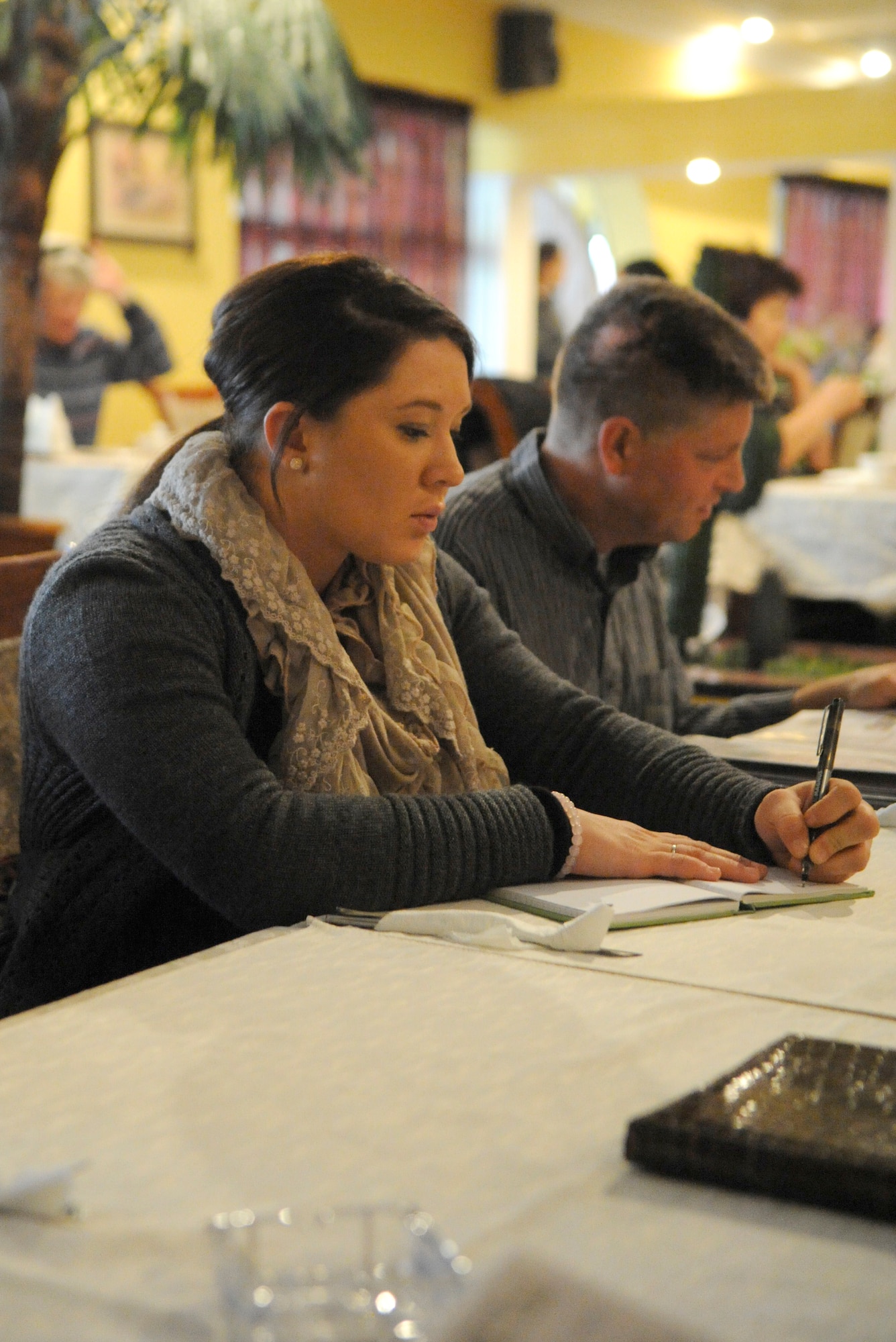 Army Spc. Jayna Marks-Rench takes notes during a lunch with three Babushkas in Bishkek, Kyrgyzstan, Oct. 25. Babushka is the Russian word for grandmother. Members of the Manas Area Benefit Outreach Society travel to Bishkek twice a month to spend time with the Babushkas. They also deliver food, personal care, and other items the ladies need. She is the MABOS vice president and Babushka focus group leader. Marks-Rench is deployed to the Transit Center at Manas as a customs official from the Minnesota Army Reserves, and a native of Rochester, Minn. (U.S. Air Force photo/Tech. Sgt. Tammie Moore)